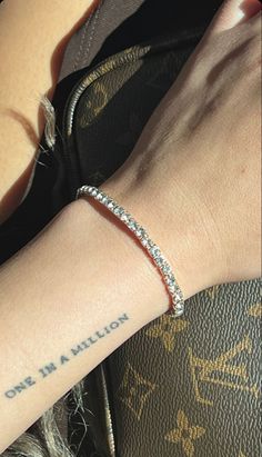 a woman's arm with a small diamond bracelet on it