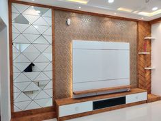 an empty room with a large flat screen tv on the wall and shelving unit