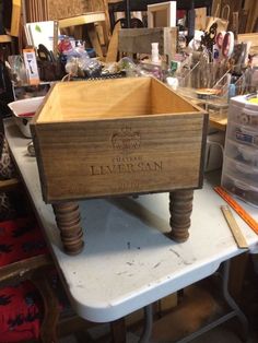 a wooden box sitting on top of a table in a room filled with other items