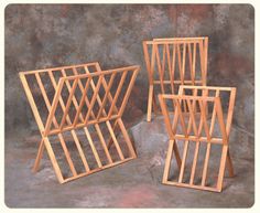 three wooden racks sitting next to each other on top of a cement floor with a wall in the background