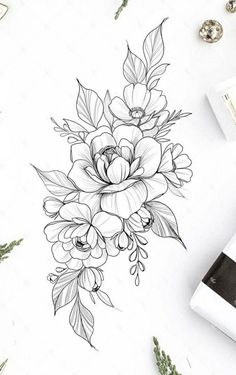 a drawing of flowers and leaves on a white paper next to some other things in the background