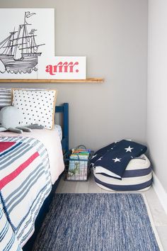 a bed room with a neatly made bed and a blue rug on the floor next to it