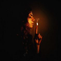 a woman holding a lit candle in her hand