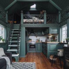 a living room filled with furniture next to a kitchen and staircase leading up to the top floor