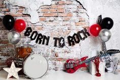 an image of a birthday party setting with balloons and guitar, drums and drum set