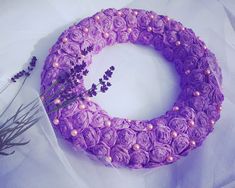 a purple wreath with pearls and lavender flowers