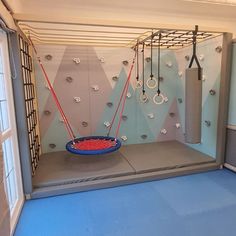 an indoor gym with swings and ropes