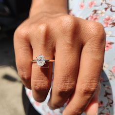 a close up of a person's hand with a diamond ring on their finger