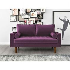 a purple couch sitting in front of a wall with pictures on it