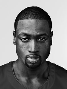 a black and white photo of a man in a football uniform looking at the camera