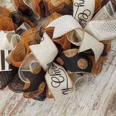 a close up of a wreath on a wooden floor with words and ribbons around it