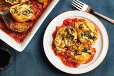 a white plate topped with ravioli next to a casserole covered in sauce