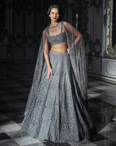 This lehenga set features heavy embroidery in tonal sequin and stone. The strappy blouse has crystal drops at the waist. The matching dupatta has crystal drops as well.From Seema Gujral's Inara collection. DELIVERY TIMEPlease allow 8-12 weeks for your outfit to arrive. FABRIC DETAILSNet Professional cleaning only. Grey Choli Lehenga, Grey Lehenga Outfit, Heavy Lehenga Designs, Grey Indian Outfit, Grey Lengha, Reception Lengha, Grey Dupatta, Shadi Dress, Strappy Blouse