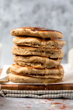 a stack of pancakes sitting on top of a wooden cutting board