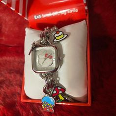 a hello kitty watch in a box on a red carpet with a keychain