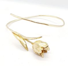 **FREE EXPRESS SHIPPING** The 14k gold cuff bracelet features a beautifully sculpted tulip flower design, showcasing exquisite craftsmanship and attention to detail At the center of the bracelet, a delicate tulip flower is elegantly crafted in gold, with a lifelike stem and two graceful leaves extending from its base The stem of the flower continues in a flowing line, wrapping gently around the entire wrist, creating a harmonious and cohesive design The bracelet is designed with an open end, allowing for easy adjustability to fit various wrist sizes. This piece combines sophistication and nature-inspired beauty, making it a stunning accessory for any occasion. Tulip size: length - 53 mm = 2 inches width - 15 mm = 0.60 inches The bracelet is custom made especially for you Please give us 3-5 Tulip Bracelet, Solid Gold Bangle, Flower Tulip, Gold Cuff Bracelet, Bangle Gold, Tulip Flower, Gold Bracelet Cuff, Gold Cuffs, Tulips Flowers