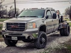 a silver truck parked on top of a dirt road