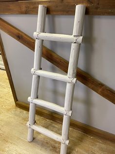 a white wooden ladder leaning against a wall