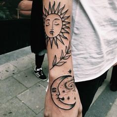 a person with a sun and moon tattoo on their arm