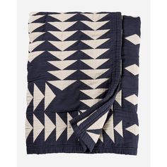 a blanket with black and white geometric designs on the front, folded in two rows