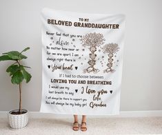 a woman standing in front of a white wall holding a blanket with the words, i love you grandma