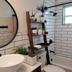 a white toilet sitting in a bathroom next to a sink and bathtub under a mirror