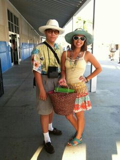 a man and woman standing next to each other in front of a building with sun glasses on