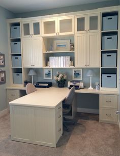 a home office with built in cabinets and desks, including an l - shaped desk