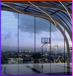 a basketball hoop in front of a large window overlooking the city at night with lights on