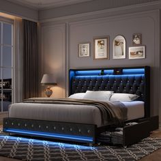 a large bed with blue lights on the headboard and foot board in a bedroom