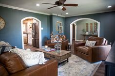 a living room filled with furniture and a ceiling fan