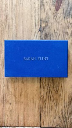 a blue business card sitting on top of a wooden table