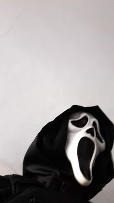 a black bag with a white mask on it