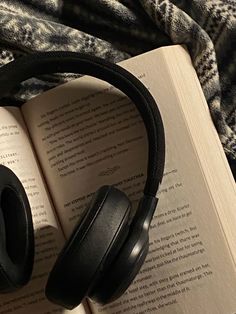 an open book with headphones on top of it