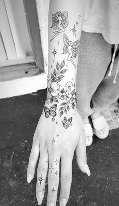 black and white photo of a person's hand with tattoos on it, holding onto the