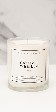 coffee and whiskey candle sitting on a white countertop next to a gray marble wall