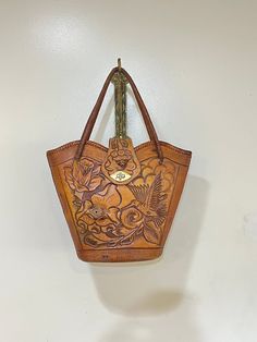 This intricate beautiful tooled leather handbag would make a perfect addition to any wardrobe.  It is a very unique market bag style and I have never seen another like it. It has beautiful 3D roses and tooling that looks like wood grain, it has an amazing hummingbird, colors and textures that you just never see.  It is actually artist signed on the bottom this is a true art piece.   In amazing condition.  I see no flaws and the tooled leather is just beautiful there is minor  wear to the interio Hummingbird Colors, Boho Retro, Vintage Tools, True Art, Tooled Leather, Bag Style, Market Bag, Leather Tooling, Leather Handbag