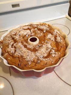 a bundt cake with powdered sugar on top sitting in a baking pan next to an oven