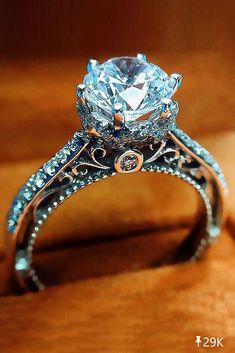 a close up view of a diamond ring on a wooden surface