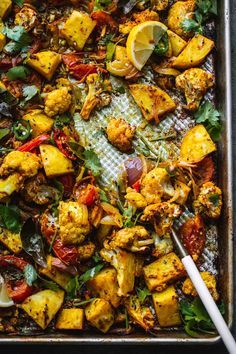 a pan filled with chicken and vegetables on top of a table