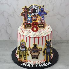 a three tiered birthday cake decorated with cartoon characters and the number eight on top