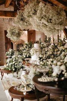 a table with flowers and candles on it in front of a chandelier hanging from the ceiling