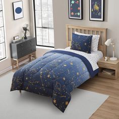 a child's bed in a bedroom with space themed comforters