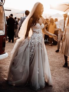 a woman in a wedding dress standing next to a van