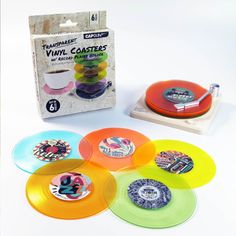 an assortment of various colored discs in front of a box with stickers on them