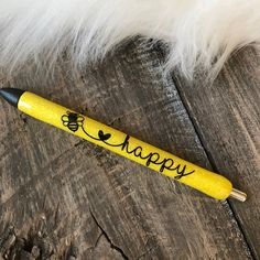 a yellow pen with the words happy written on it