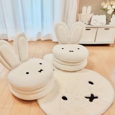 the white rugs are shaped like bunnies with faces on them and ears sticking out