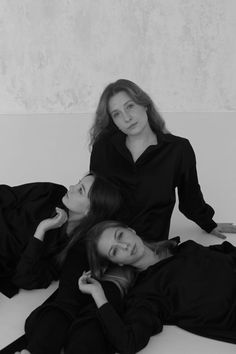 three women laying on the floor in black and white