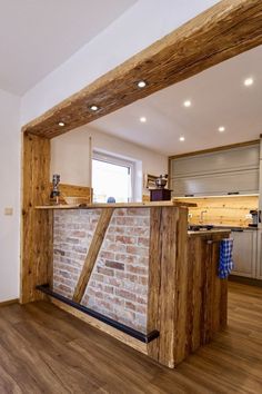 an empty kitchen with brick and wood accents