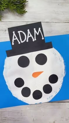 a paper plate with a snowman on it and the word mada written in white